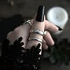 pale hand with long black nails and two sterling silver rings