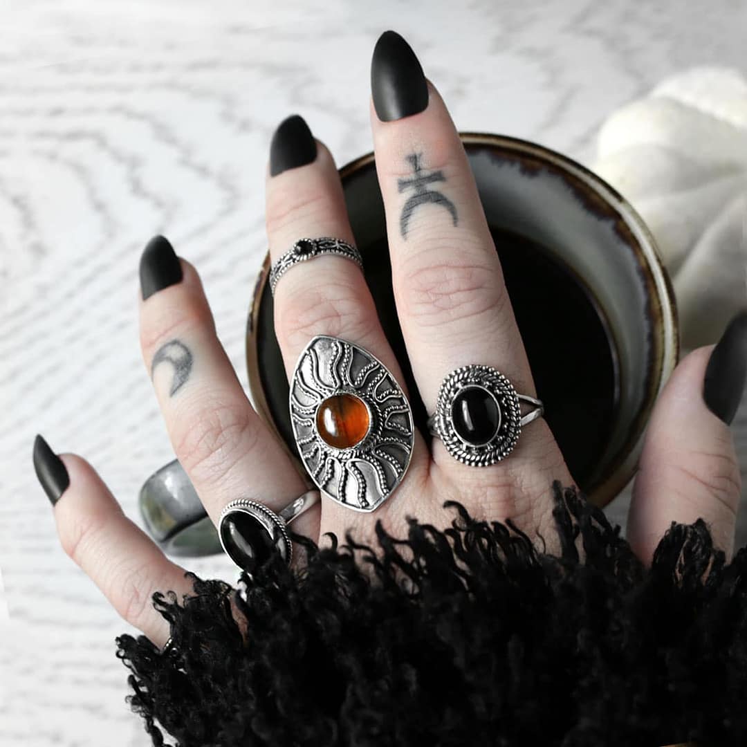 gaia-onyx-silver-ring-warriors-call-amber-silver-ring-nathalia-onyx-silver-ring-hellaholics (1) Amber Shield Viking Ring - large amber silver ring paird with black onyx silver rings holding a cup of coffee, autum vibes