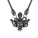 An antique silver-colored statement necklace with the symbol "Medusa".