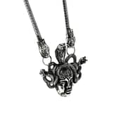 An antique silver-colored statement necklace with the symbol "Medusa".