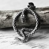 The Queens Serpent Silver Snake Necklace, Close up image on brown branch -- light background