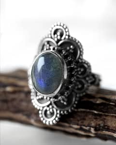 Spellbinding oval Sterling Silver Labradorite ring with intricate details, in blue and green colours on white background