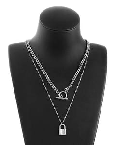 Two chain necklaces hanging on a black necklace bust display. One lock pendant hanging in a thin chain, above it hangs a chunky chain choker in stainless steel. White background