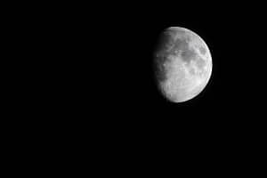 Moon symbolism image for moon jewellery with a full moon in grey on black background