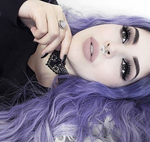 alternative model tavujeus wears a purple wig with black lipstick and hellaholics 90s lace choker