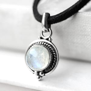Close-up of Riya Moonstone necklace, a round sterling silver pendant with moonstone. on white background.