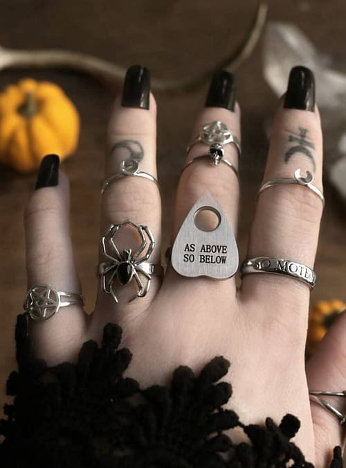 Occult rings, black long nails and finger tattoos.