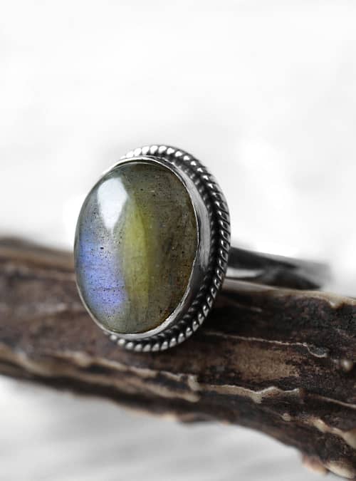 Spellbinding oval Sterling Silver Labradorite ring in blue and green colours on wooden branch