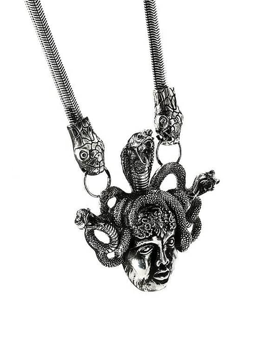 An antique silver-colored statement necklace with the symbol "Medusa".