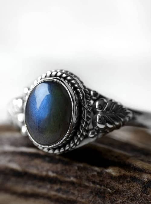 Spellbinding oval Sterling Silver Labradorite ring with intricate leaf details, in blue and green colours on white background, side view