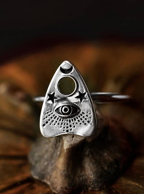 Recycled sterling silver ring with Ouija Spirit board detailed symbol, the ring sits on a pumpkin surrounded by a dark background