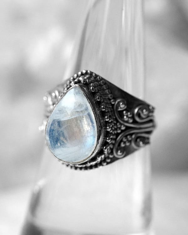 Drop-shaped large sterling silver moonstone ring, close-up photo on neutral background
