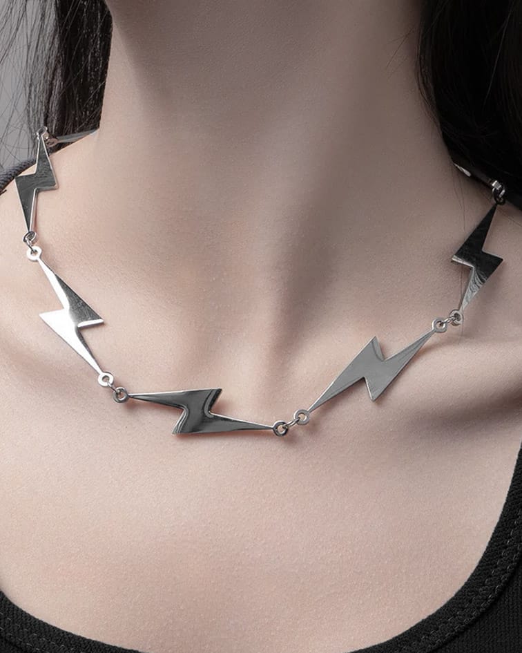 Bolt Lightning Necklace in stainless steel with 5 lightning pendants visible, hangning on a womans neck. Steel grey colour.