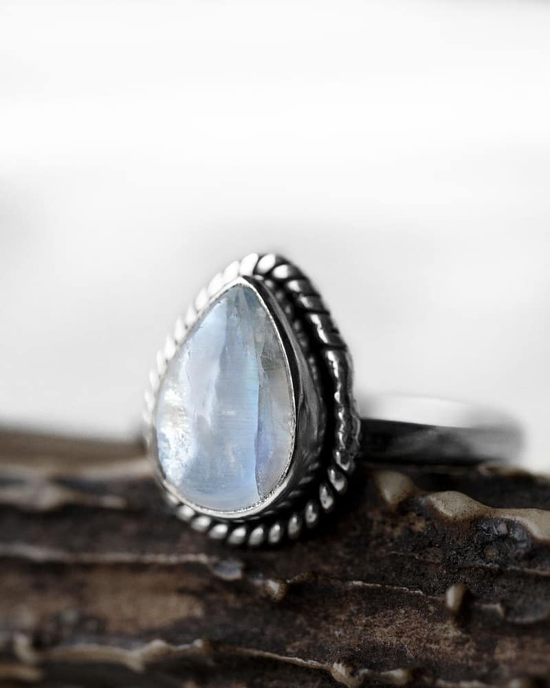Drop-shaped moonstone silver ring on brown branch