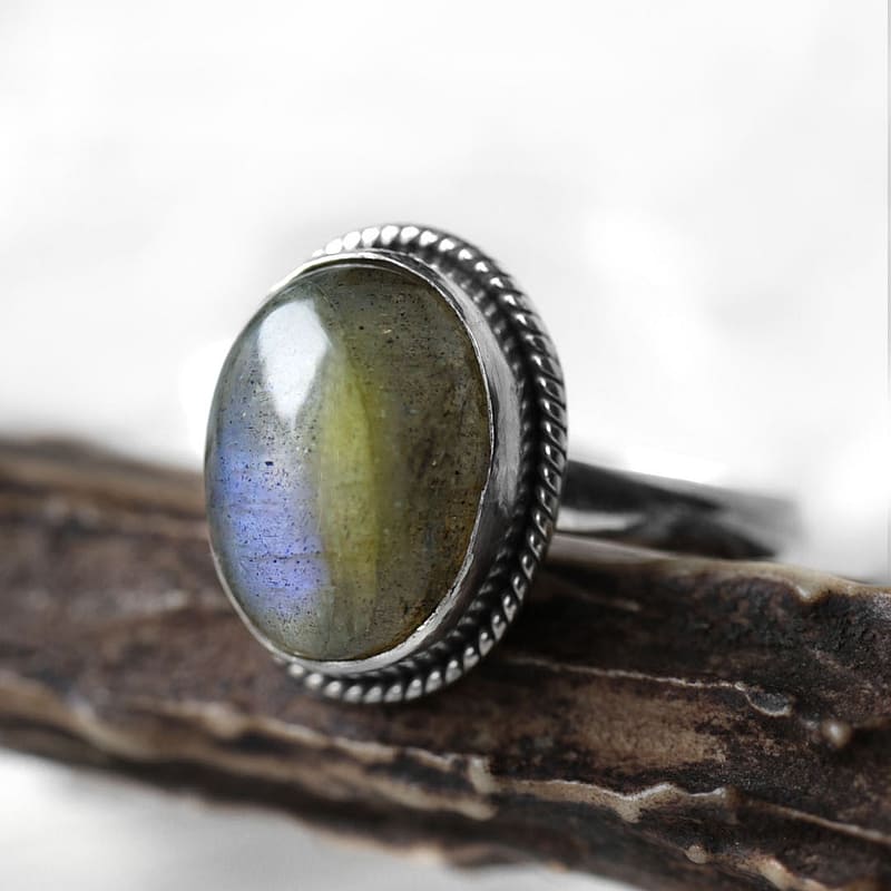 Spellbinding oval Sterling Silver Labradorite ring in blue and green colours on wooden branch