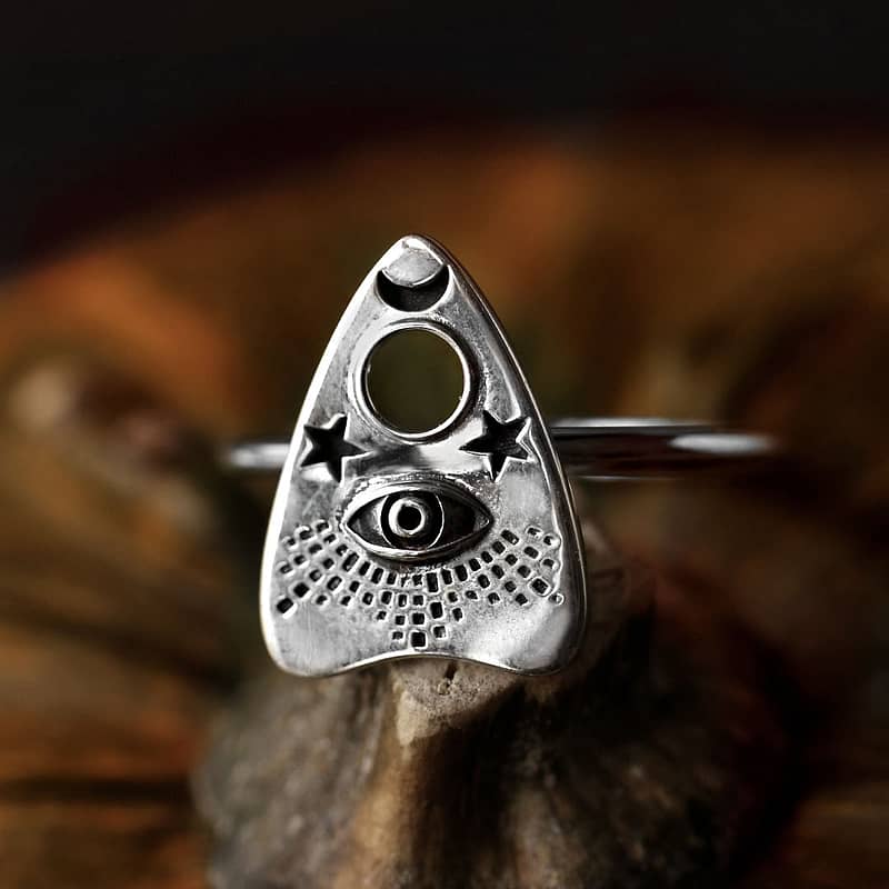 Recycled sterling silver ring with Ouija Spirit board detailed symbol, the ring sits on a pumpkin surrounded by a dark background