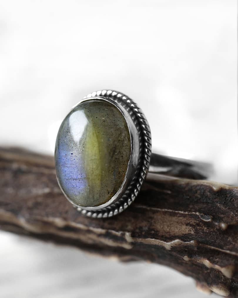 Spellbinding oval Sterling Silver Labradorite ring in blue and green colours on wooden branch