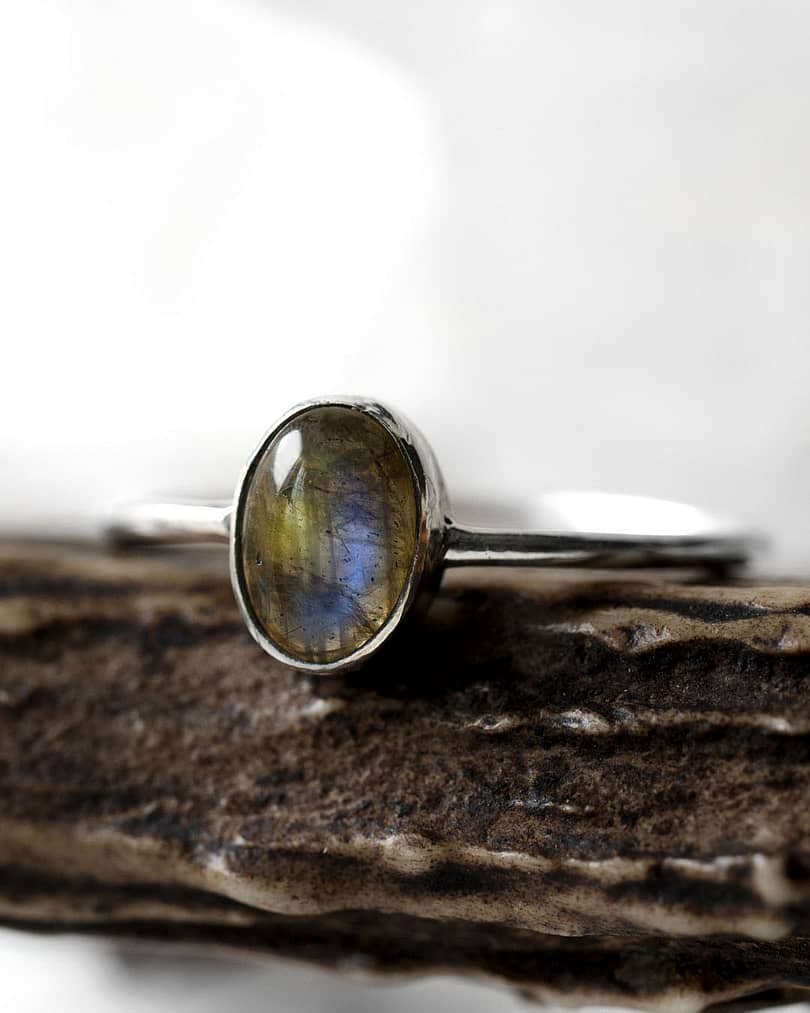 Spellbinding smal oval Sterling Silver Labradorite ring in blue and green colours on white background