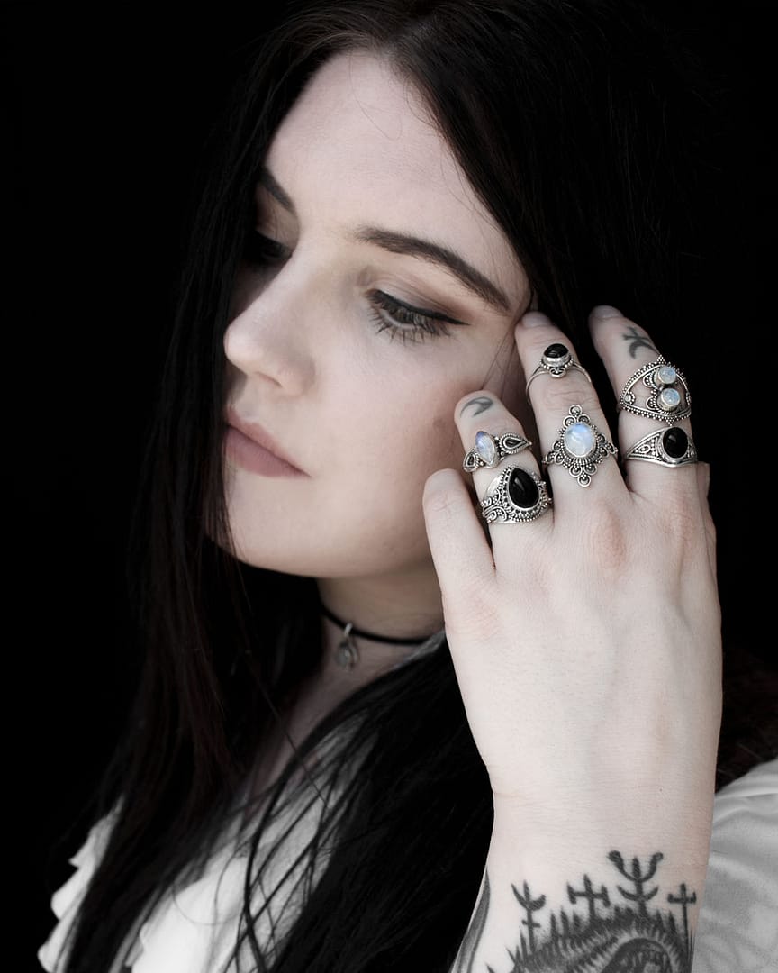 Arianba silver moonstone ring worn by a pale girl with black hair and tattoos