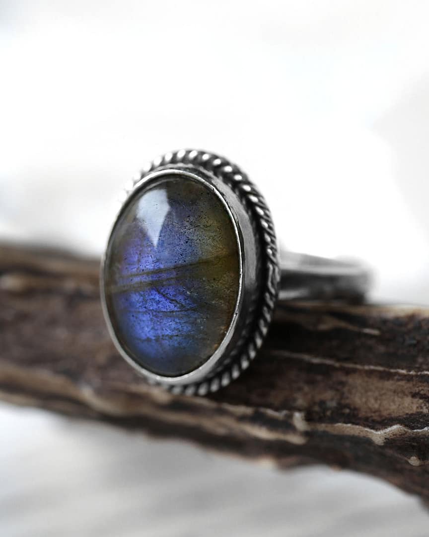 gaia-labradorite-silver-ring-close-up-2-hellaholics Spellbinding oval Sterling Silver Labradorite ring in blue and green colours on wooden branch