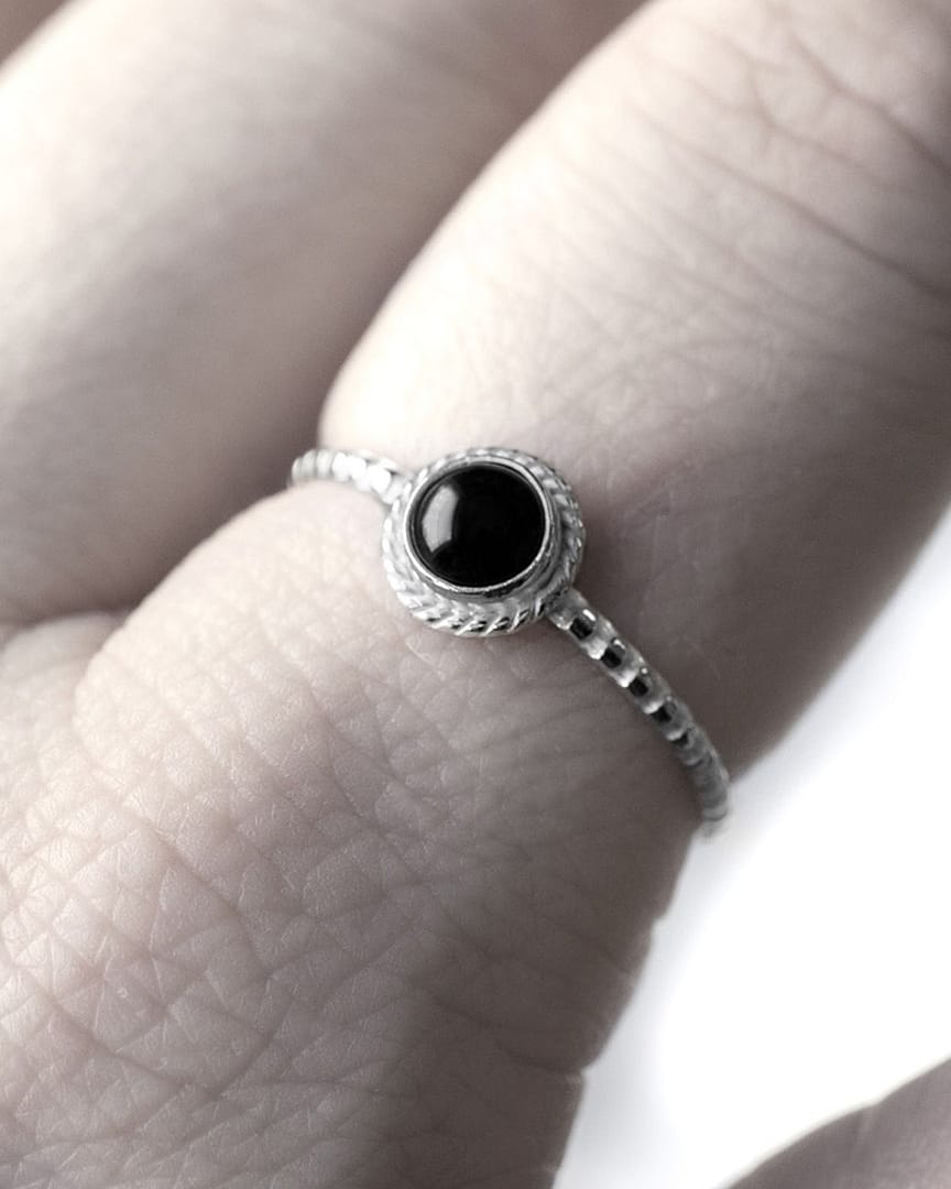 asteria-silver-onyx-stacking-ring-model-close-up-hellaholics Round petite black Onyx Stacking Ring in lightweight sterling silver on finger